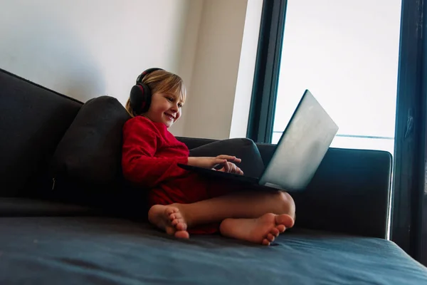 Dziewczynka uczy się zdalnie w domu, dzieciak z laptopem w domu — Zdjęcie stockowe