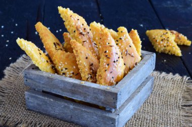 Susam gri bir arka plan üzerinde mezarda ile tuzlu bisküvi.