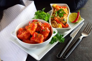 Beyaz bir kase içinde ananas ve biber domates soslu tavuk güveç