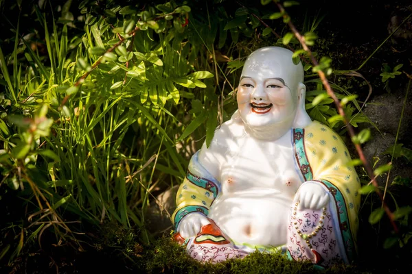 Smiling Buddha Hotey figurine in green grass — Stock Photo, Image