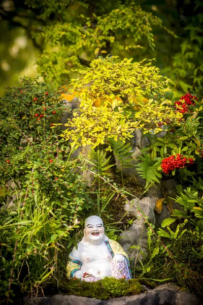 Smiling Buddha Hotey figurine in green grass — Stock Photo, Image