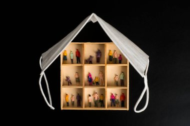 Covid-19, Coronavirüs enfeksiyonundan korunmak için maske kullan. Aileleri olan bir ev ve çatı olarak bir maske..