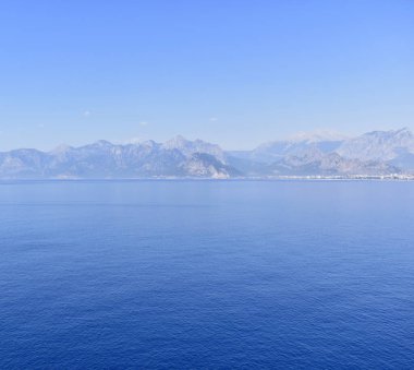 Ufukta dağlar olan deniz manzarası