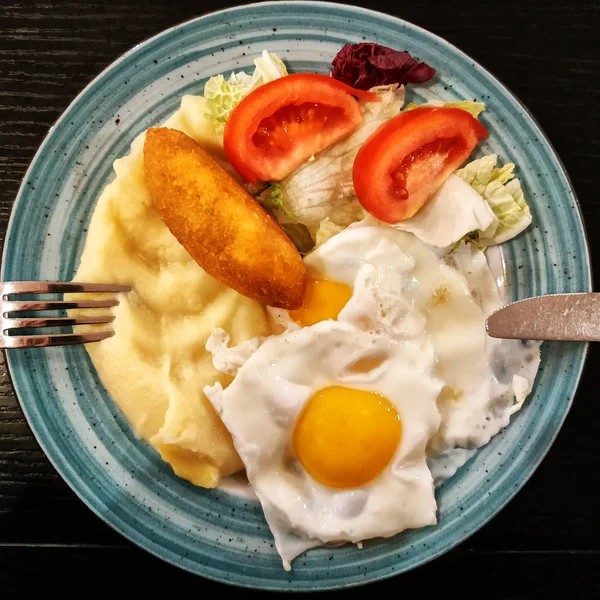 İştah açıcı yemek: patates, yumurta, pirzola ve salata ile kahvaltı