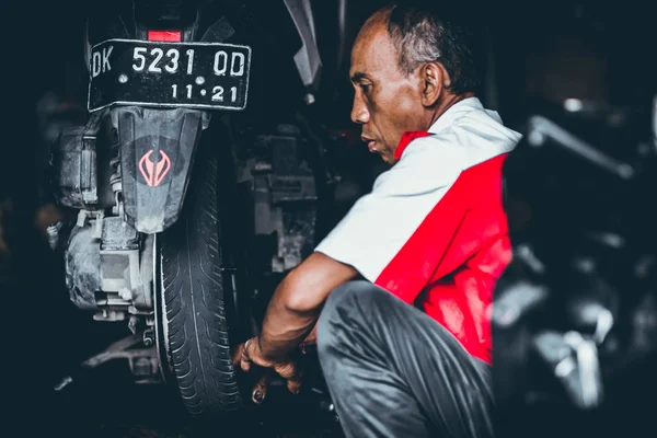 BALI, INDONESIA - 17 Mei 2018: Penggantian ban sepeda motor, pemasangan di garasi. Skuter kumbang sedang diperbaiki . — Stok Foto