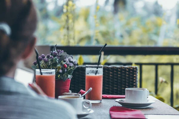 Genç kadın Bali adasında tatil lüks sırasında orman manzaralı sabah bir fincan kahve içme.