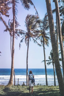 Avuç içi ağaçları arasında genç kadın. Bali Adası.