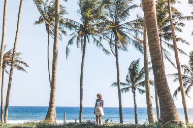 Avuç içi ağaçları arasında genç kadın. Bali Adası.