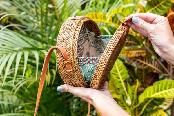 Modieuze, stijlvolle rotan tas in de tropische tuin. — Stockfoto