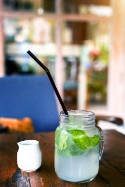 Ahşap masa üzerinde taze içecek limonata mojito. Mojito nane yaprakları, kireç ve buz, açık.