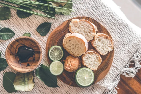 新鮮な緑のライムの木製テーブルの上のパンをスライス. — ストック写真