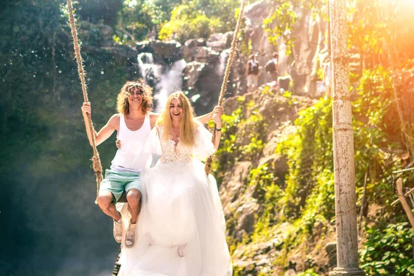 Pareja de luna de miel joven se balancea en la selva cerca del lago, isla de Bali, Indonesia . — Foto de Stock