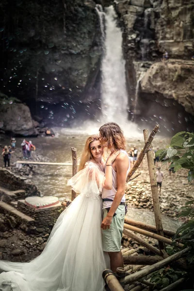 Bella coppia di nozze contro cascata al tramonto, isola tropicale di Bali . — Foto Stock