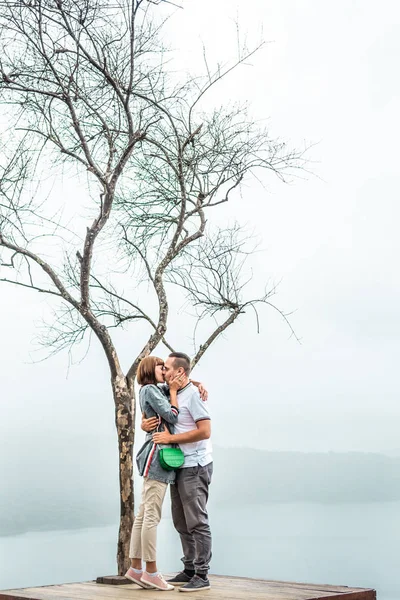 A view of a loving couple posing on the beautiful white sky backgorund on th cliff. Bali island. — Stock Photo, Image