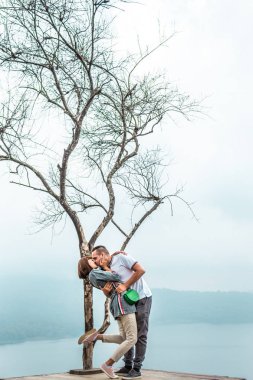 Sevgi dolu bir çift güzel beyaz gökyüzü backgorund th cliff üzerinde poz bir görüntü. Bali Adası.