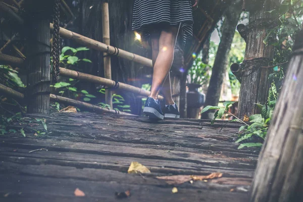 Kvinna fötter på en rustik träbro. Ön Bali. — Stockfoto