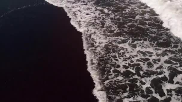 4K vista aérea superior voando vídeo de uma praia com areia vulcânica preta. Ilha de Bali . — Vídeo de Stock