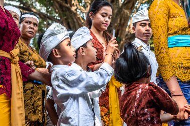 Bali, Endonezya - 25 Eylül 2018: Bali dili çocuklarda Tirta Empul Tapınağı büyük bir törenle geleneksel kıyafet.