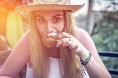 Genç kadın kahve ve çay orman yağmur ormanlarında bir tropikal Bali adasının günbatımı sırasında tatma.