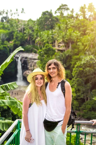 Young honeymoon couple in the jungle on the watefall background. Bali island.