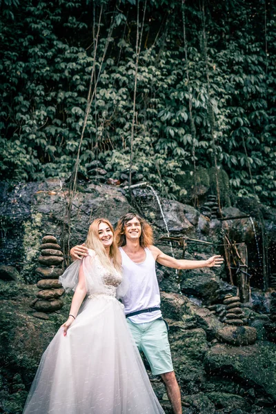 Incredibile vista romantica di coppia felice nella foresta pluviale dell'isola di Bali vicino alla cascata . — Foto Stock