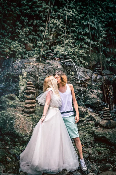 Amazing romantic view of happy couple in the rainforest of Bali island close to waterfall. — Stock Photo, Image