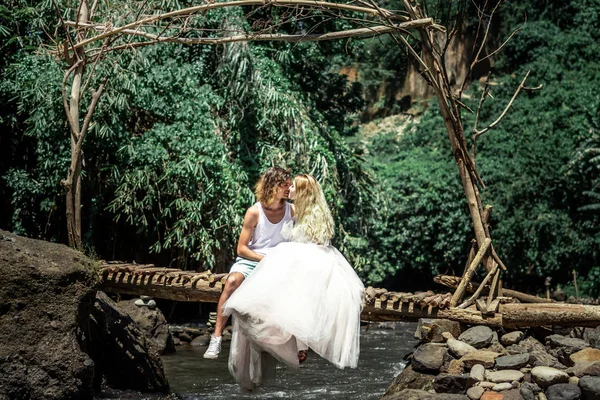 Young honeymoon newleds couple kissing on a mountain river. Bali island. — Stock Photo, Image