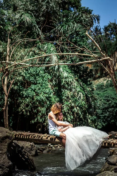 Giovane luna di miele coppia di sposi su un fiume di montagna. Isola di Bali . — Foto Stock