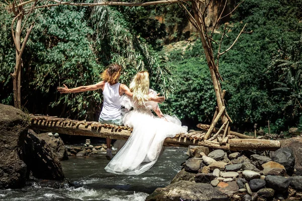 Young honeymoon newleds couple on a mountain river. Bali island. — Stock Photo, Image