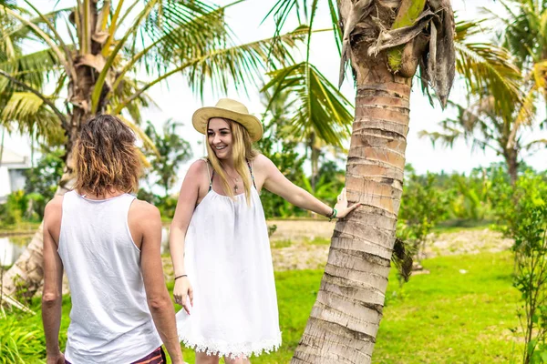 Młoda romatic para turystycznej pod palm kokosowych. Jasny obraz zielony i żółty. Wyspa Bali. Indonezja. — Zdjęcie stockowe