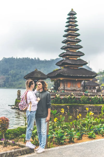 Ρομαντικό ζευγάρι του trourists σχετικά με το ιστορικό του ναού Ουλάν κοστίζει. Νησί του Μπαλί. — Φωτογραφία Αρχείου