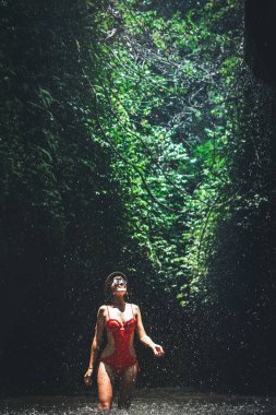 Genç kadın backpacker ormanlarda şelale bakarak. Eko-turizm kavramı görüntü seyahat kız. Bali Adası.