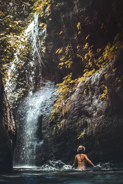 Fiatal nő hátizsákos nézi a vízesés a dzsungel. Ökoturizmus koncepció kép utazási lány. Bali szigetén. — Stock Fotó