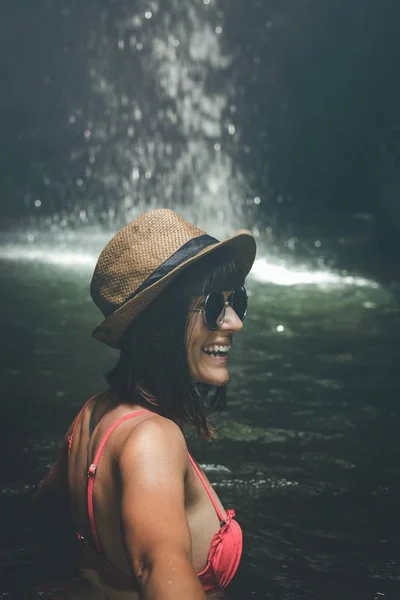 Jonge vrouw voor toeristen in de diepe jungle met waterval. Echte avontuur concept. Bali eiland. — Stockfoto