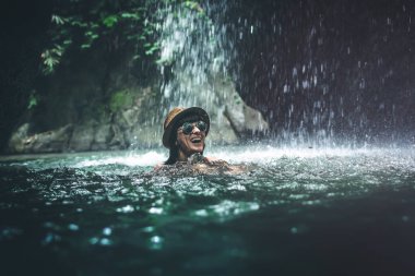 Mutlu genç kadın turist derin orman şelale yüzme. Gerçek bir macera kavramı. Bali Adası.