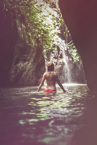 Fiatal nő turisztikai vízesés mély dzsungelben. Igazi kaland fogalma. Bali szigetén. — Stock Fotó