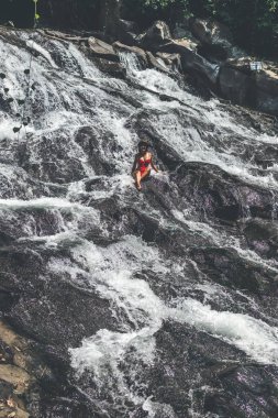 Art arda sıralı şelale Bali Adası üzerinde kırmızı mayo genç kadın.