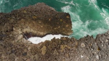 4k hava video sahilde, volkanik kayaçların dalgalar kayalar üzerine çökmesini robot. Bali Adası.