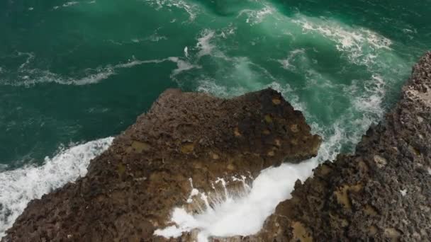 Vídeo de drones aéreos 4K de rocas volcánicas en la playa, olas estrellándose contra rocas. Isla de Bali . — Vídeo de stock