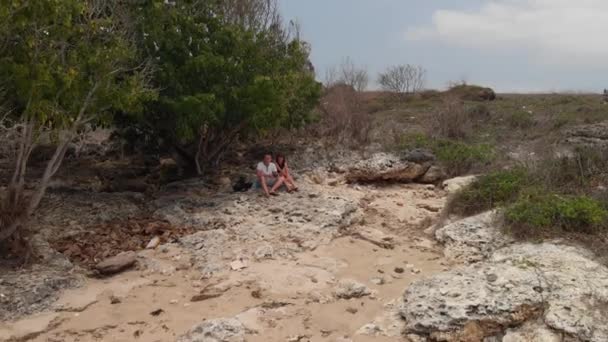 4k lotnicze latanie drone wideo Młoda Para turystów na dzika plaża skalista. Wyspa Bali. — Wideo stockowe