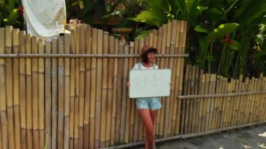Beyaz tahta metin seyahat ile tutan genç kadın. Drone görüntüleri uçan kavramı, seyahat. Yeşil arka plan. Bali Adası.