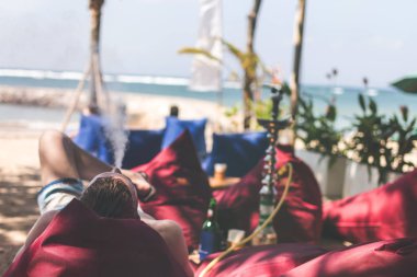 Adam sigara nargile bir sahil tarafı restoranı deniz yanında tarih. Shisha yasaktır. Bali Adası.