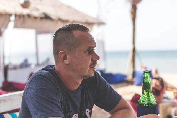 Homme buvant de la bière dans un restaurant de plage, Bali île . — Photo