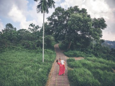Genç çift Bali adasının ormanda yolda poz.