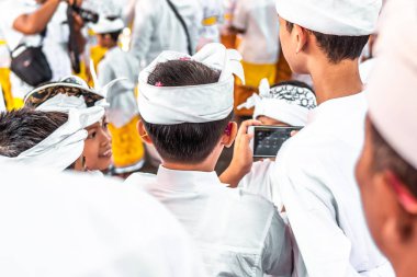 Bali, Endonezya - 9 Ekim 2018: Bali Ubud geleneksel bir törenle Smartphone'da çocuklarla.