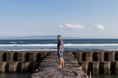 Genç adam bir sahil arka planda, Bali Adası.