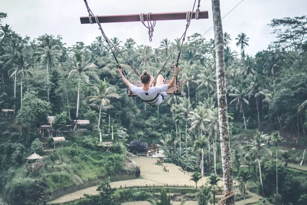 Mujer joven turista balanceándose en la selva de la isla de Bali . — Foto de Stock