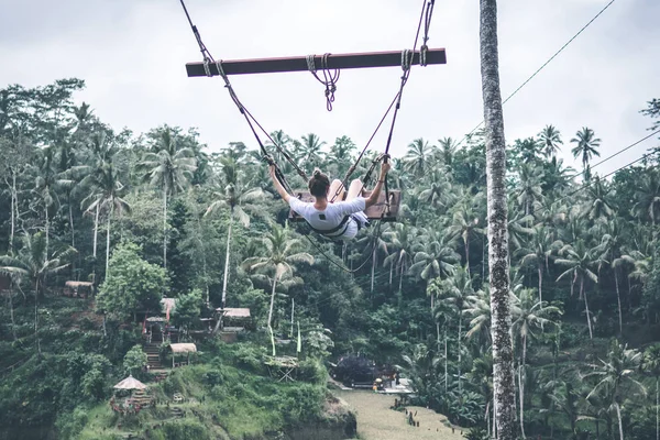Mujer joven turista balanceándose en la selva de la isla de Bali . — Foto de Stock