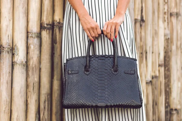 Kadın elleriyle lüks el yapımı yılan derisi deri çanta. Piton yılan moda çanta. Açık havada, Bali Adası.