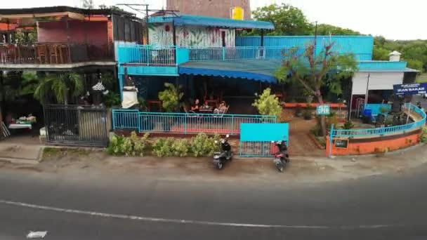 Bali, indonesien - 19. Dezember 2018: Drohnenvideo eines jungen Paares in einem Fischrestaurant im Freien. bali-Insel. — Stockvideo